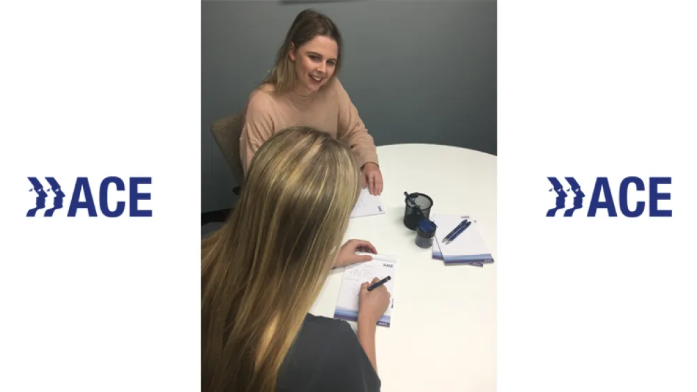 Two girls sat at a classroom table