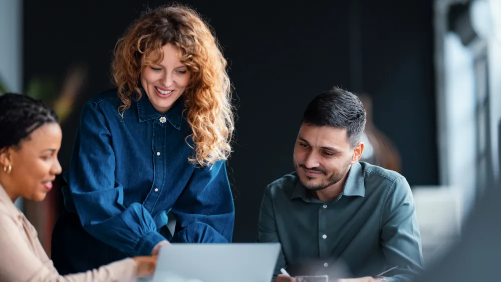 People working in a PMO looking at a laptop