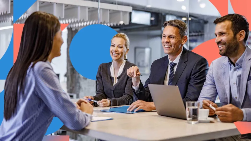 Team of professionals in a business meeting, smiling and collaborating around a table.
