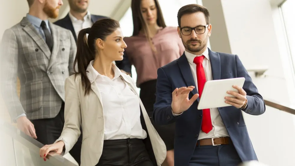 Group of businesspeople discussing documents on a modern staircase